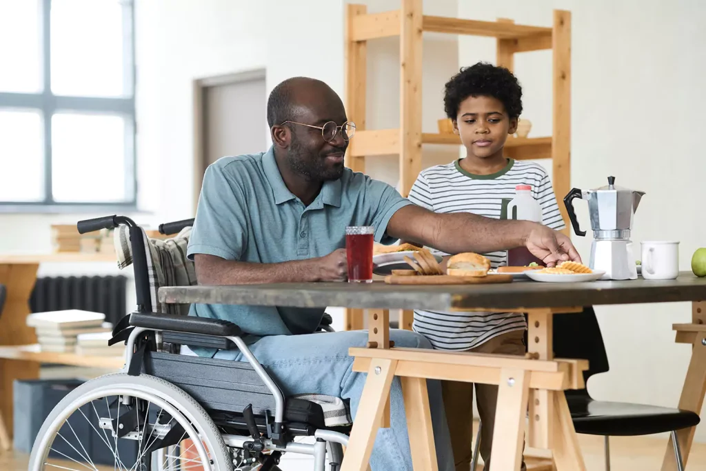 Disabled man in wheelchair at home with son
