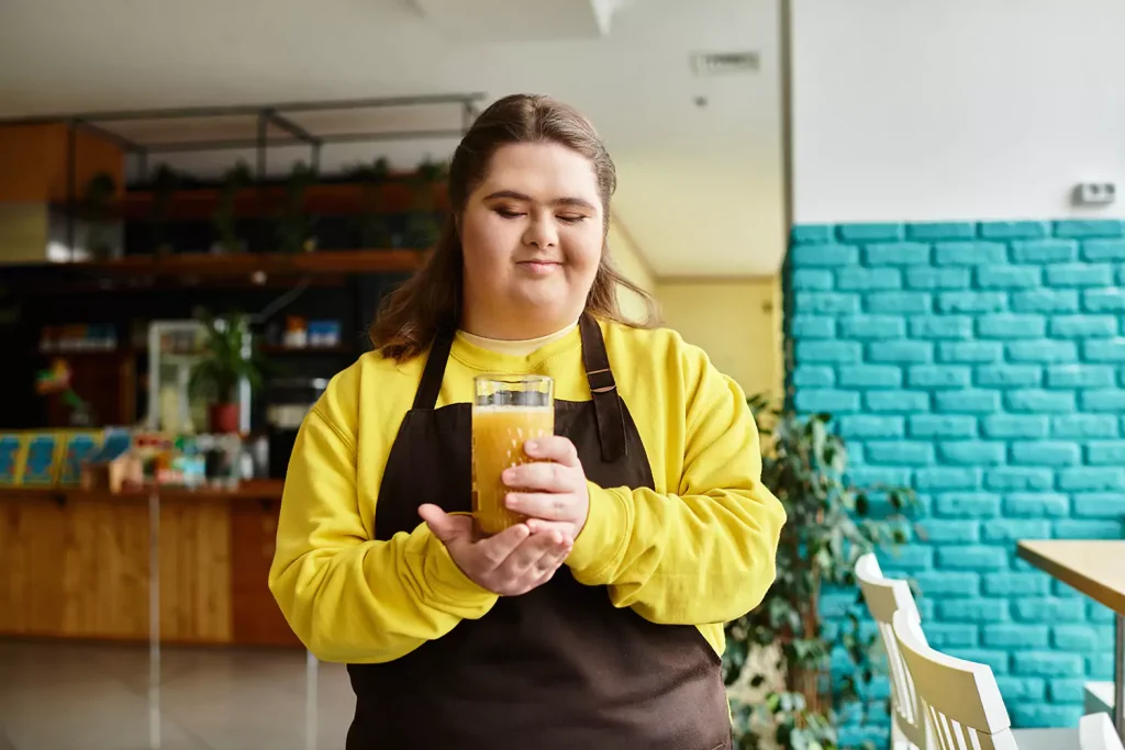 Disabled woman with down syndrome drinking orange juice